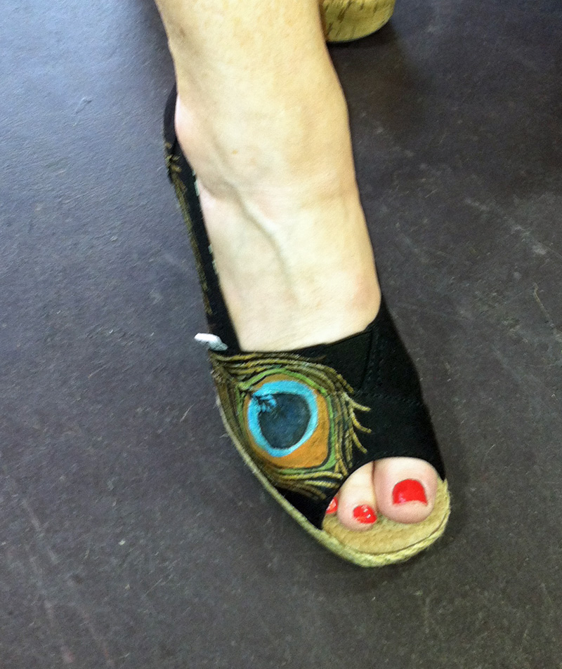 hand painted peacock feather adorns a wedge style toms shoe Peacock feather painted on wedge toms style