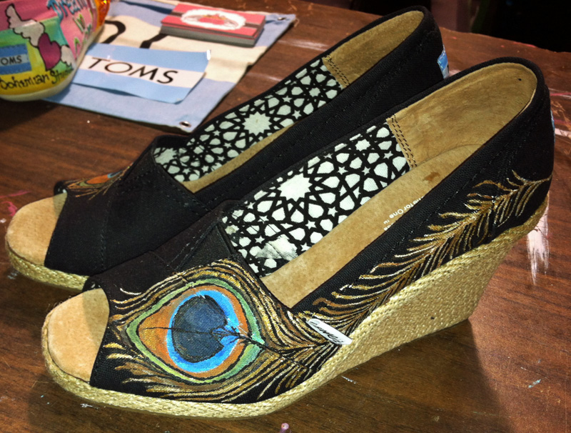 hand painted peacock feather adorns a wedge style toms shoe Peacock feather painted on wedge toms style
