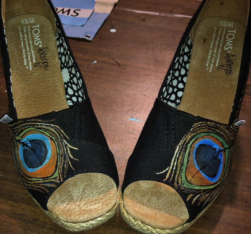 hand painted peacock feather adorns a wedge style toms shoe Peacock feather painted on wedge toms style