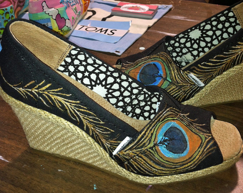 hand painted peacock feather adorns a wedge style toms shoe Peacock feather painted on wedge toms style
