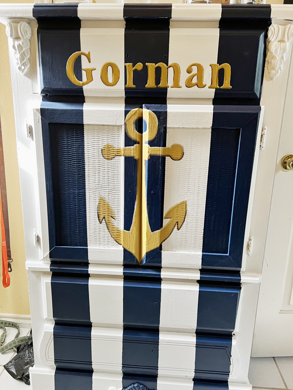 navy and white striped small armoire dresser with a gold anchor and a name painted on the front