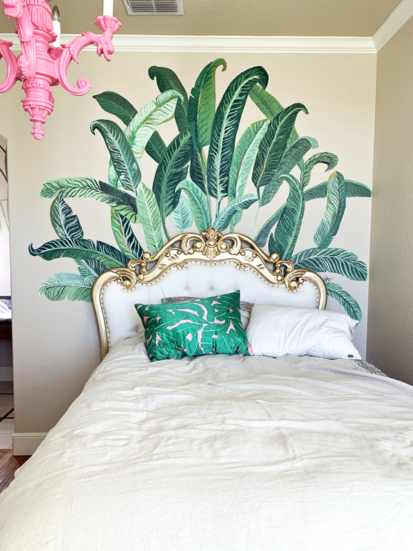 hand painted banana leaf mural on a bedroom wall