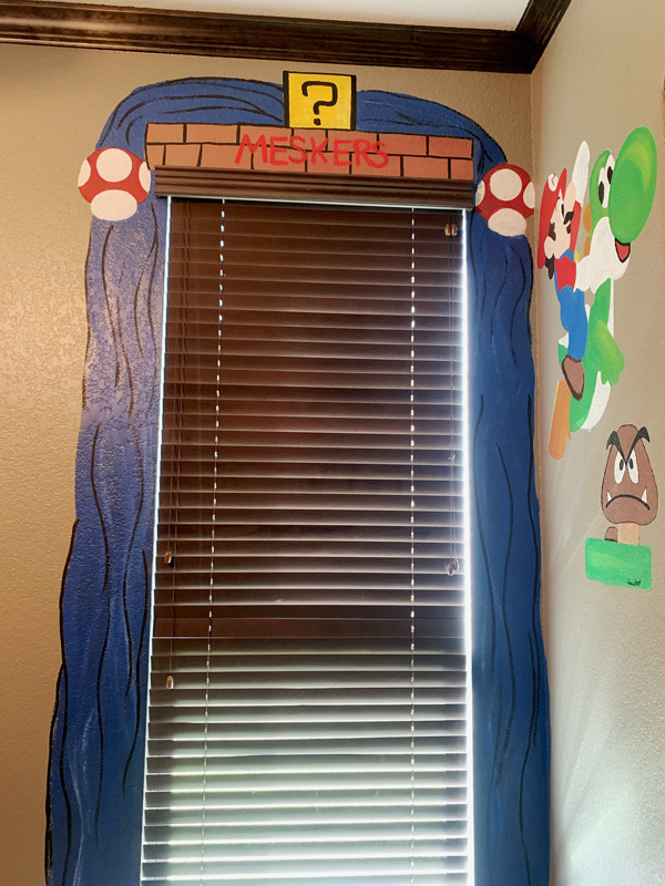 a mural of Mario brothers elements painted in a boys bedroom