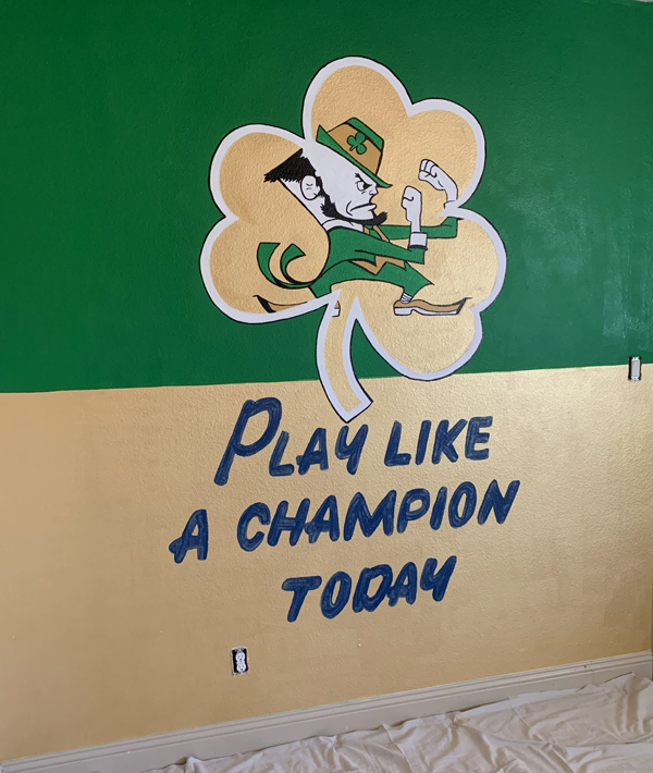 hand painted mural of the fighting irish on a green and golf wall with play like a champion today