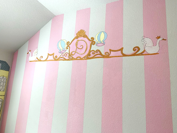 mural in a girls bedroom with pink stripes and a monogram