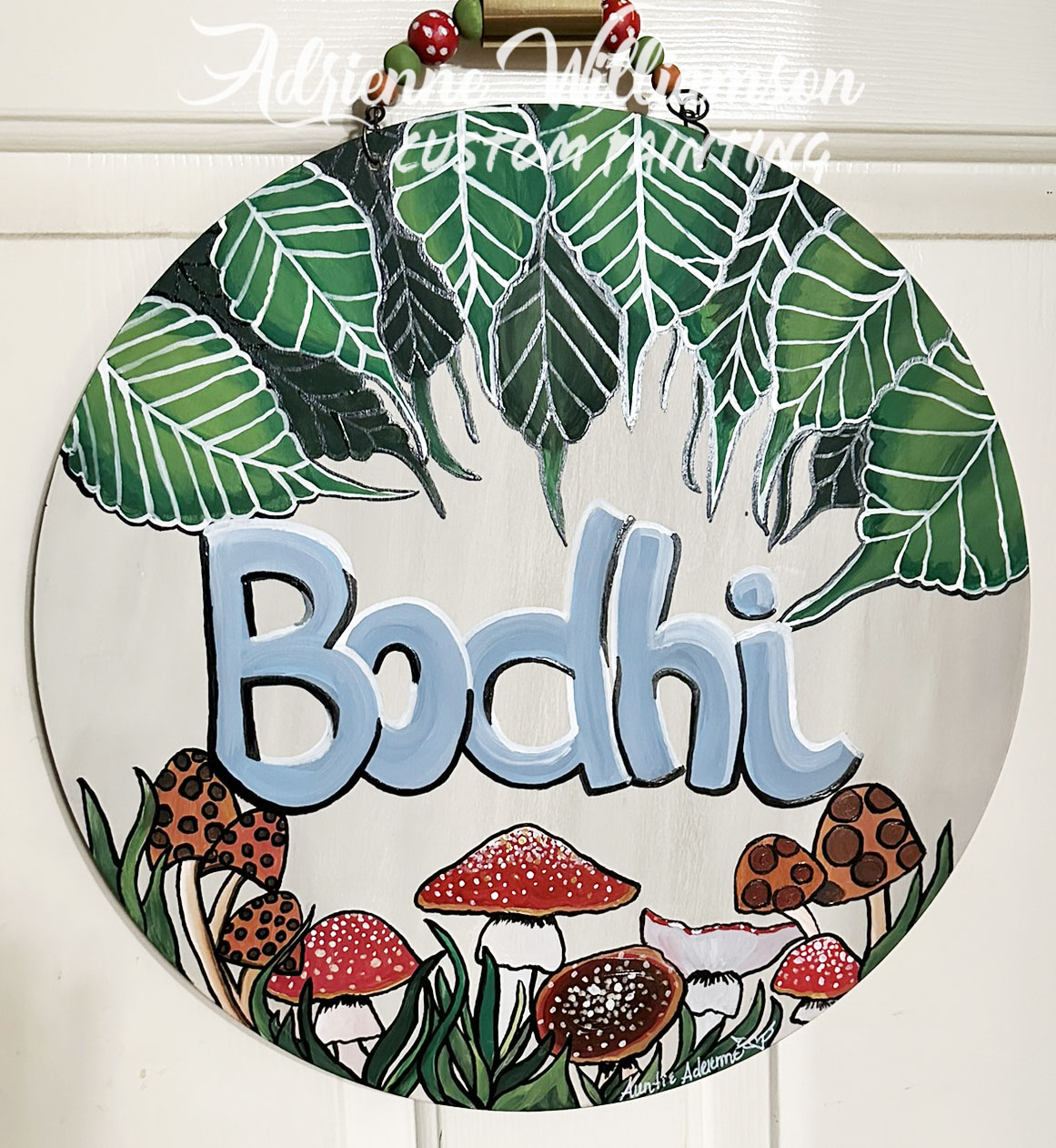 painted door sign hanging on interior door with mushrooms and a name